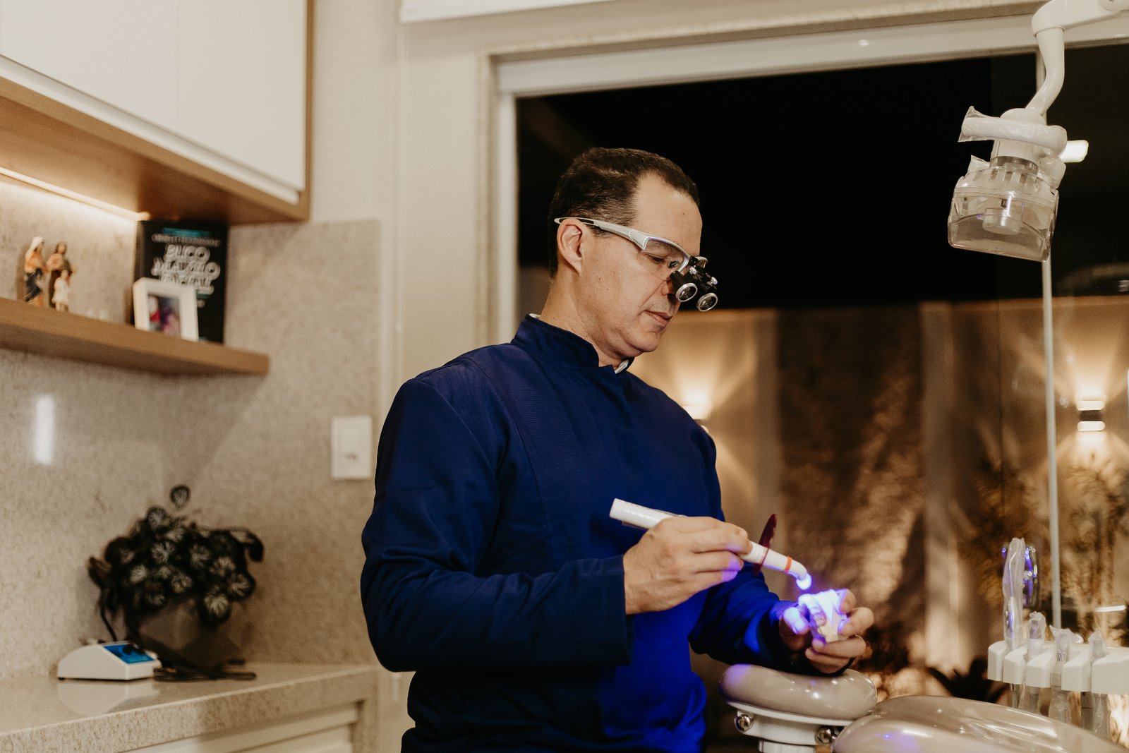 Dentista realizando procedimento com fotopolimerizador